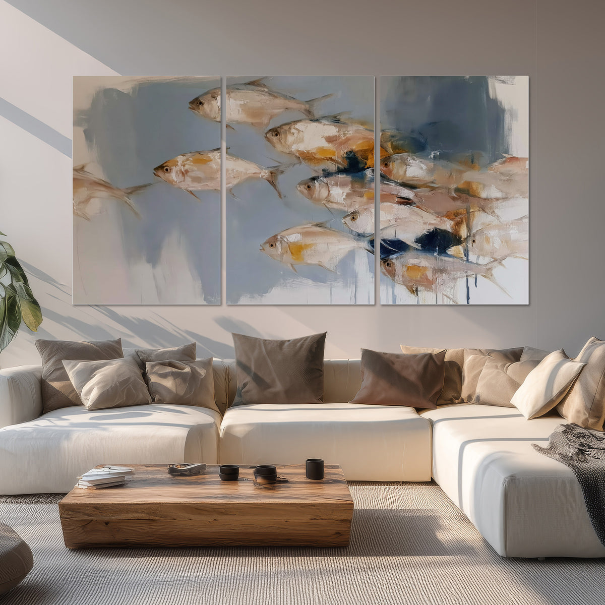 Small blue and golden fish moving across a pale layered abstract background set of 3 poster prints displayed in a living room