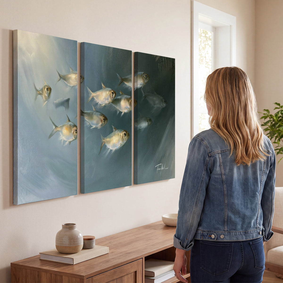 A small school of pale golden fish swimming across dark blue-green water 3 piece canvas wall art three panel arrangement on a wall