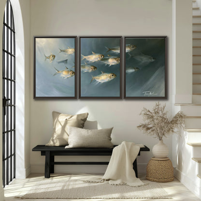 A small school of pale golden fish swimming across dark blue-green water 3 piece framed canvas wall art displayed in a entryway