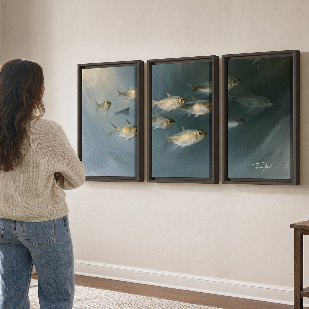 A small school of pale golden fish swimming across dark blue-green water 3 piece framed canvas wall art three panel arrangement on a wall