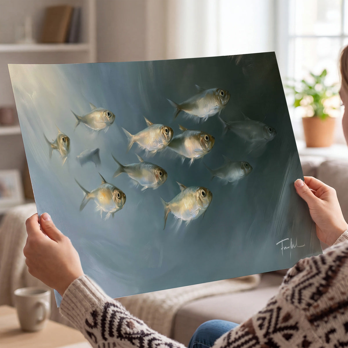 A small school of pale golden fish swimming across dark blue-green water single poster print held in hands
