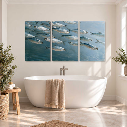 A school of silver fish moving together through cool blue water 3 piece canvas wall art styled in an interior