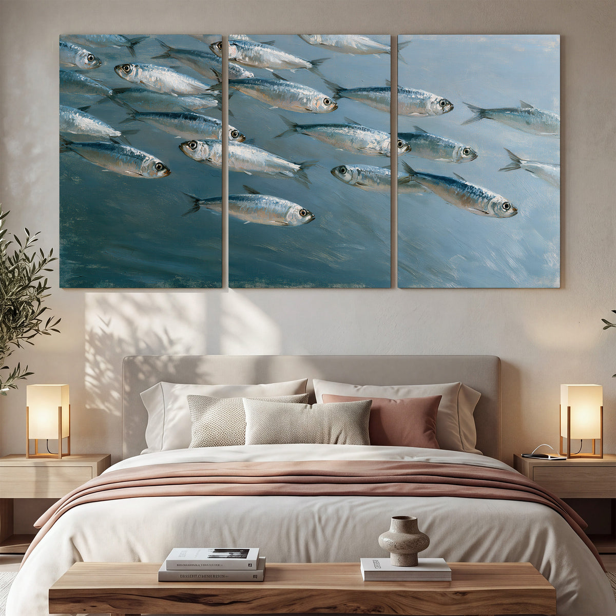 A school of silver fish moving together through cool blue water 3 piece canvas wall art displayed in a bedroom