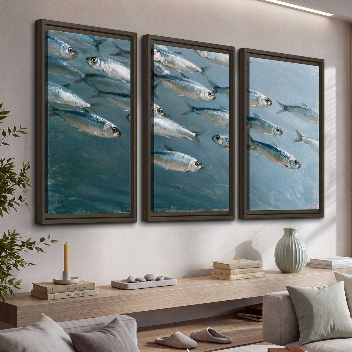A school of silver fish moving together through cool blue water 3 piece framed canvas wall art displayed in a console
