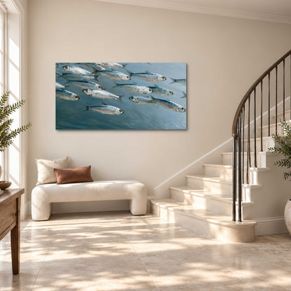 A school of silver fish moving together through cool blue water single canvas wall art styled in an interior