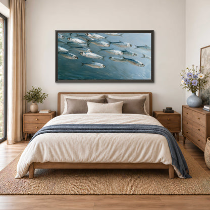 A school of silver fish moving together through cool blue water single framed canvas wall art styled in an interior