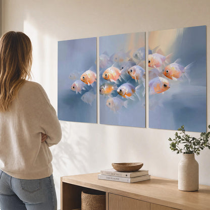Rounded peach and gold fish floating in a softly lit blue underwater scene set of 3 poster prints three panel arrangement on a wall