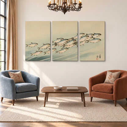 A flowing school of small fish above pale blue water on a cream ground 3 piece canvas wall art styled in an interior