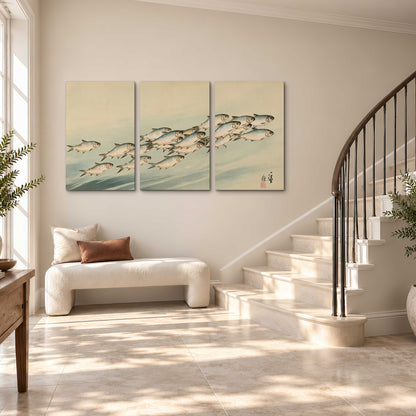 A flowing school of small fish above pale blue water on a cream ground 3 piece canvas wall art styled in an interior