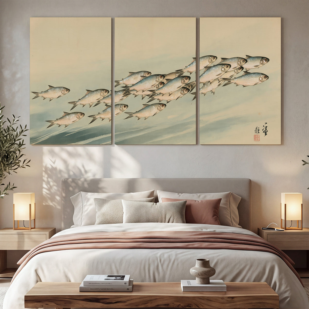 A flowing school of small fish above pale blue water on a cream ground 3 piece canvas wall art displayed in a bedroom