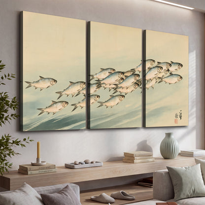A flowing school of small fish above pale blue water on a cream ground 3 piece canvas wall art displayed in a console
