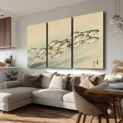 A flowing school of small fish above pale blue water on a cream ground 3 piece canvas wall art room and product view