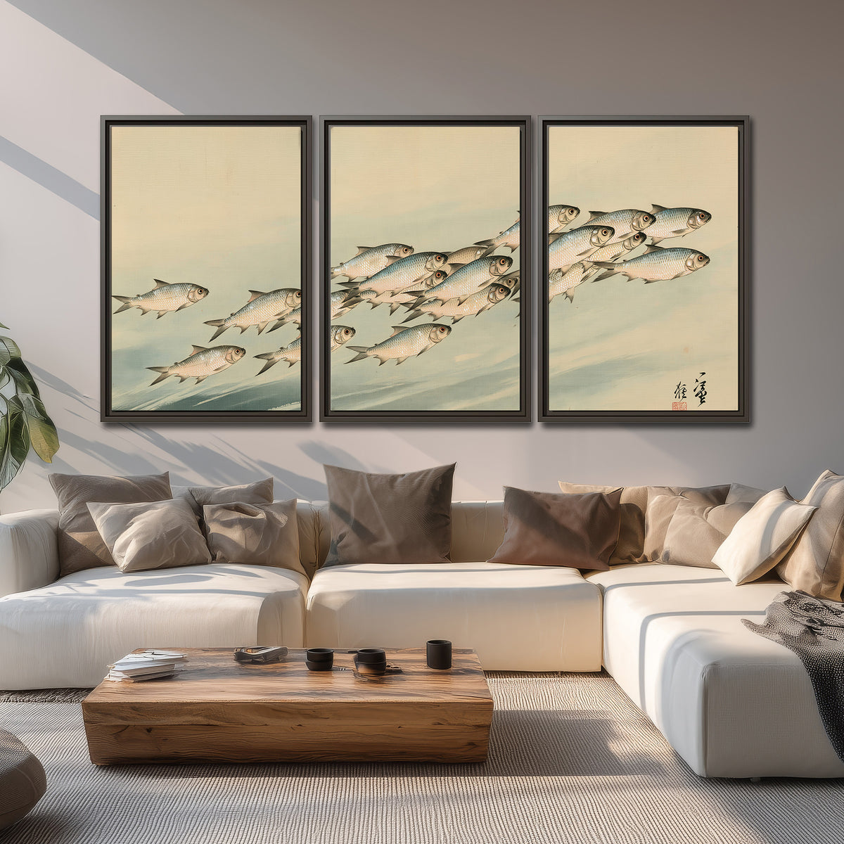 A flowing school of small fish above pale blue water on a cream ground 3 piece framed canvas wall art displayed in a living room