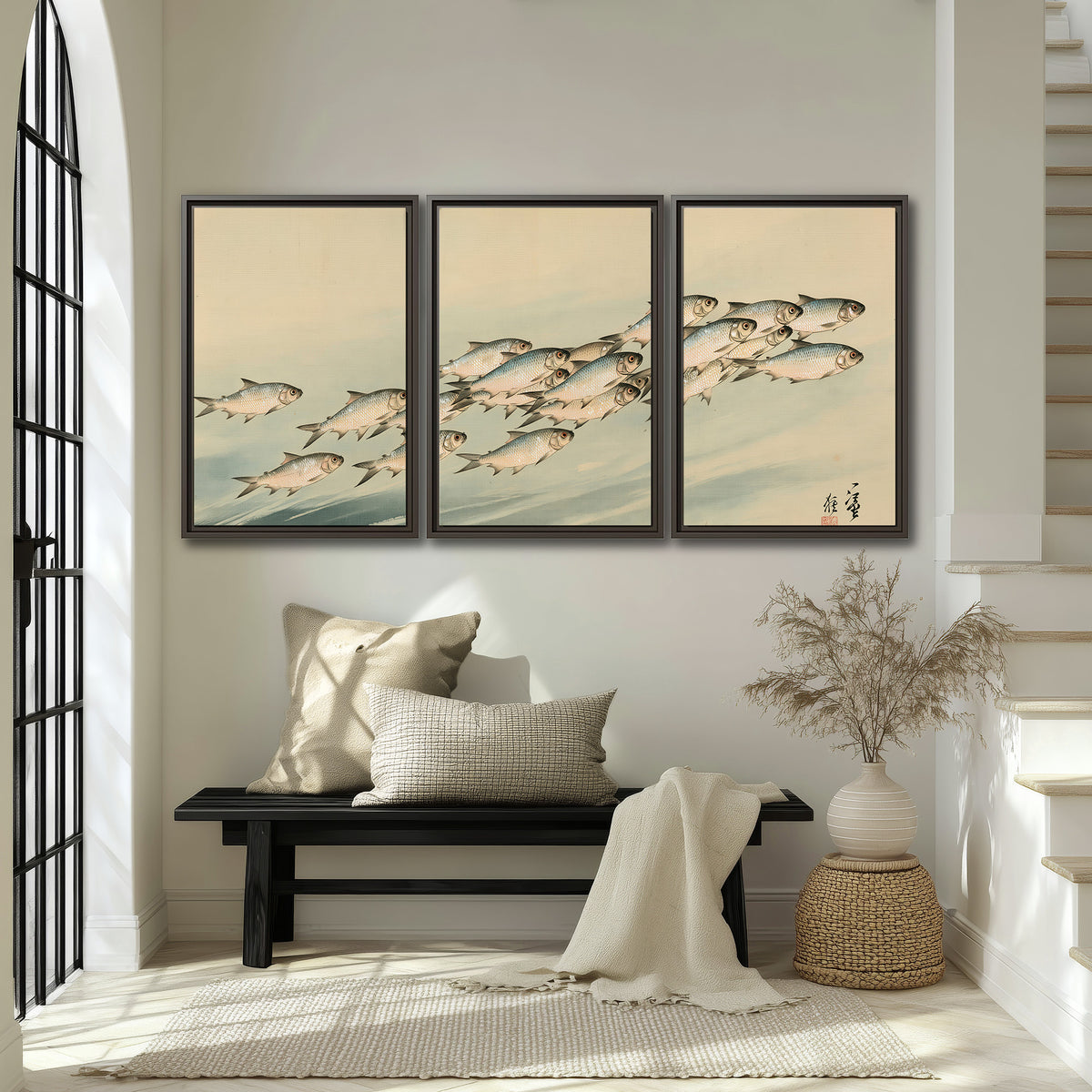 A flowing school of small fish above pale blue water on a cream ground 3 piece framed canvas wall art displayed in a entryway