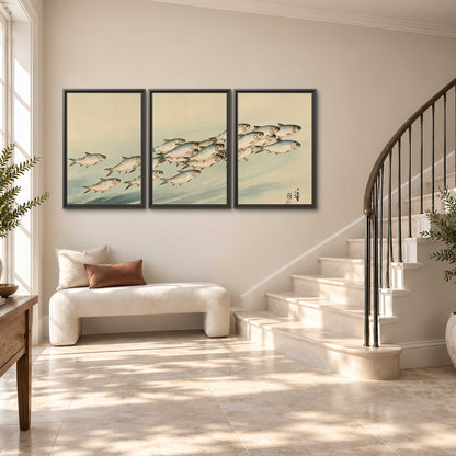 A flowing school of small fish above pale blue water on a cream ground 3 piece framed canvas wall art styled in an interior