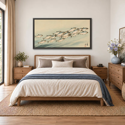 A flowing school of small fish above pale blue water on a cream ground single framed canvas wall art styled in an interior