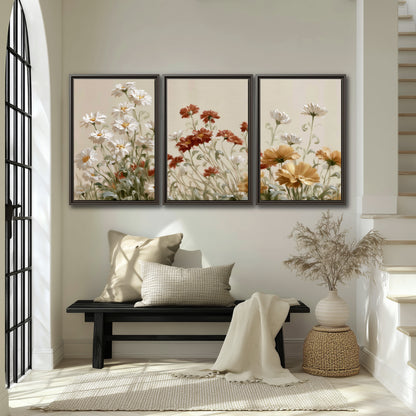 Loose ivory, rust and golden wildflowers on a soft neutral background 3 piece framed canvas wall art displayed in a entryway
