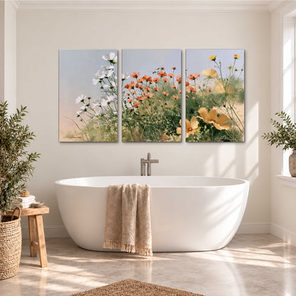 White and orange meadow flowers with fine green stems under a pale sky 3 piece canvas wall art styled in an interior