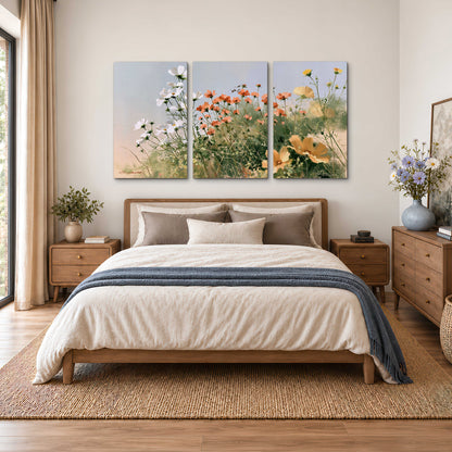 White and orange meadow flowers with fine green stems under a pale sky 3 piece canvas wall art styled in an interior