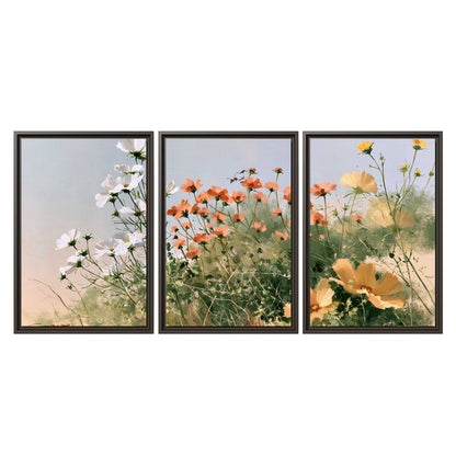 White and orange meadow flowers with fine green stems under a pale sky 3 piece framed canvas wall art viewed straight on