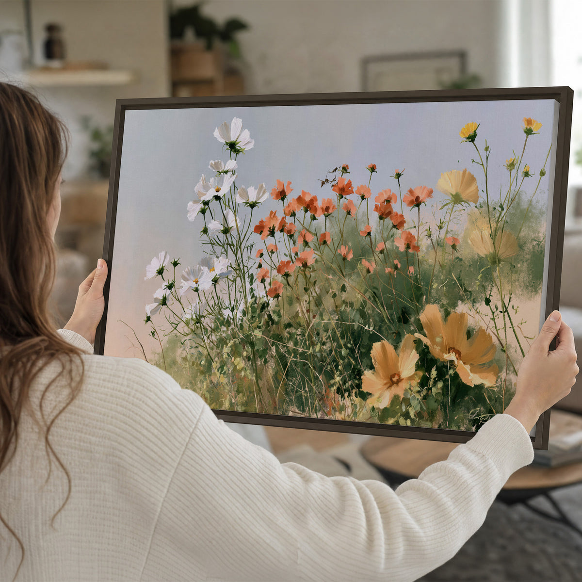 White and orange meadow flowers with fine green stems under a pale sky single framed canvas wall art held in hands
