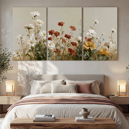 White wildflowers and warm red blossoms rising against a soft beige background 3 piece canvas wall art displayed in a bedroom