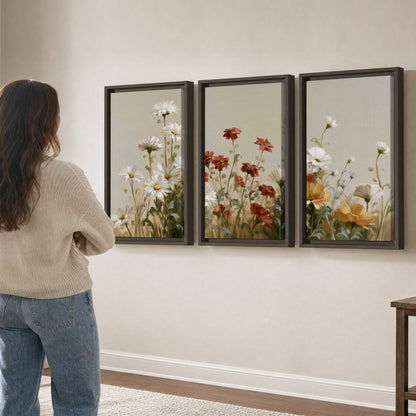 White wildflowers and warm red blossoms rising against a soft beige background 3 piece framed canvas wall art three panel arrangement on a wall
