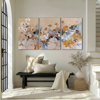 Loose blue and ochre blossoms layered across a warm neutral background 3 piece canvas wall art displayed in a entryway