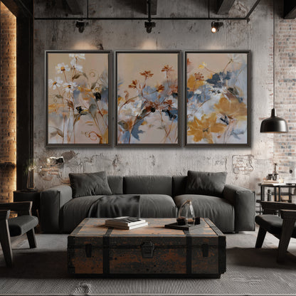 Loose blue and ochre blossoms layered across a warm neutral background 3 piece framed canvas wall art displayed in a industrial room