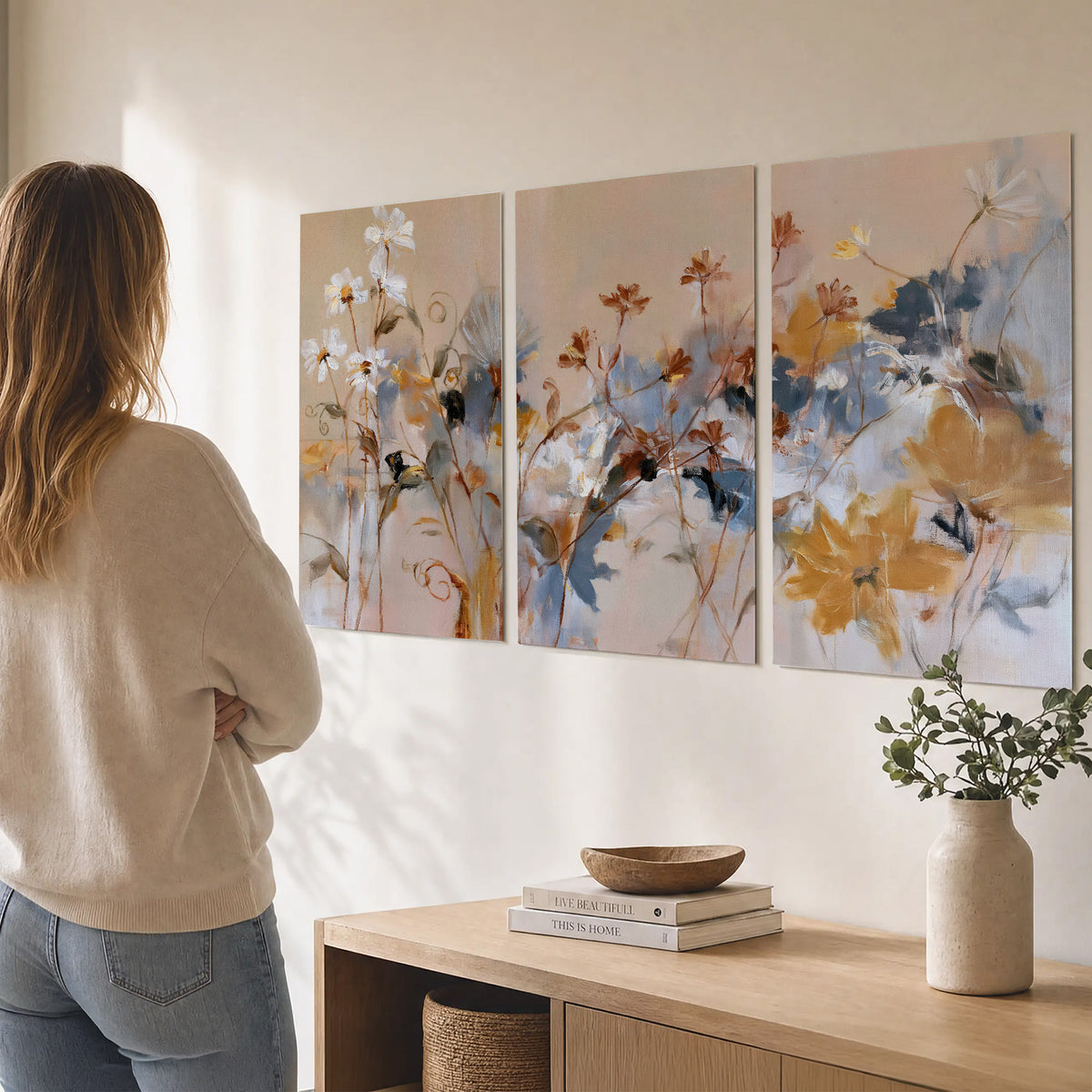 Loose blue and ochre blossoms layered across a warm neutral background set of 3 poster prints three panel arrangement on a wall