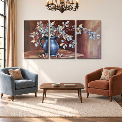 White flowering branches gathered in a deep blue pitcher against a warm rust-colored wall 3 piece canvas wall art styled in an interior