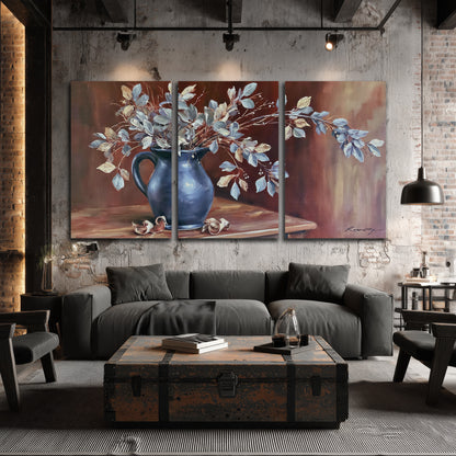 White flowering branches gathered in a deep blue pitcher against a warm rust-colored wall 3 piece canvas wall art displayed in a industrial room