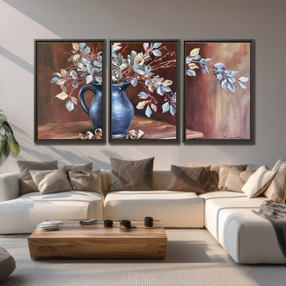 White flowering branches gathered in a deep blue pitcher against a warm rust-colored wall 3 piece framed canvas wall art displayed in a living room