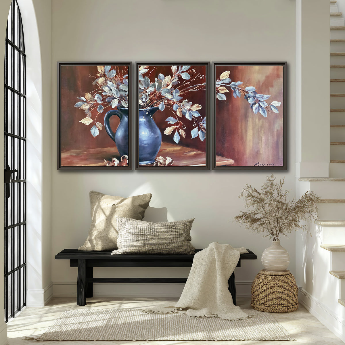 White flowering branches gathered in a deep blue pitcher against a warm rust-colored wall 3 piece framed canvas wall art displayed in a entryway