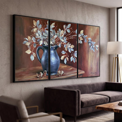White flowering branches gathered in a deep blue pitcher against a warm rust-colored wall 3 piece framed canvas wall art displayed in a modern living room