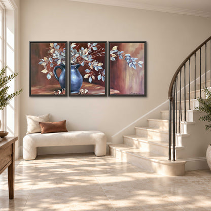 White flowering branches gathered in a deep blue pitcher against a warm rust-colored wall 3 piece framed canvas wall art styled in an interior