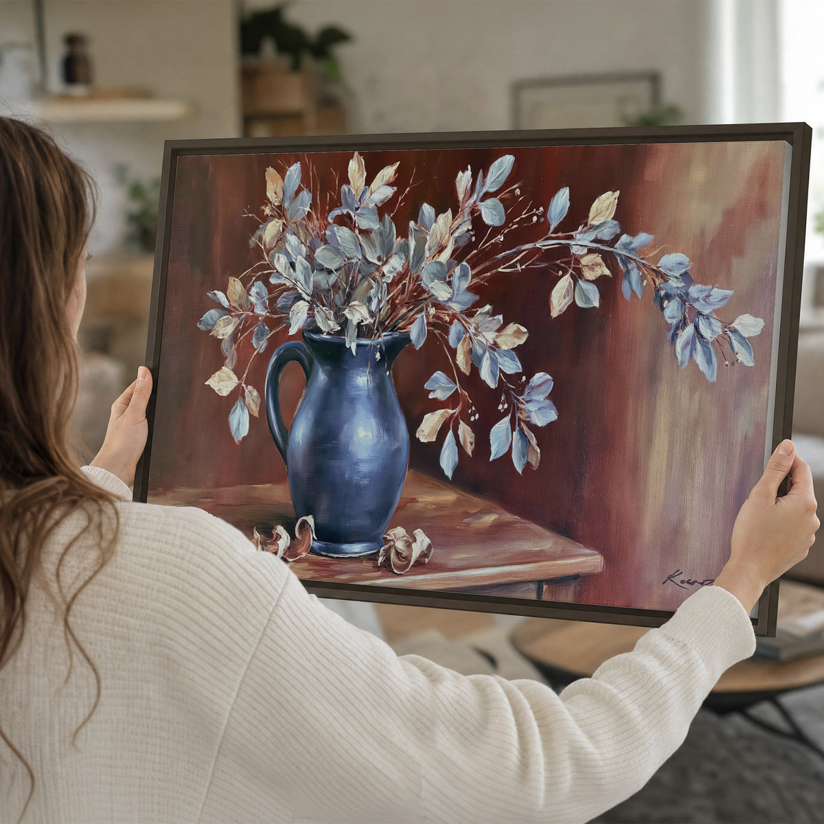 White flowering branches gathered in a deep blue pitcher against a warm rust-colored wall single framed canvas wall art held in hands