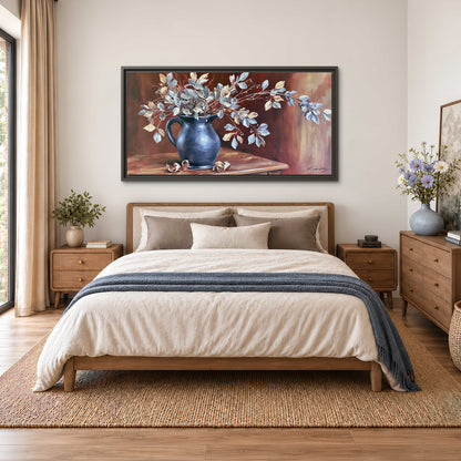 White flowering branches gathered in a deep blue pitcher against a warm rust-colored wall single framed canvas wall art styled in an interior