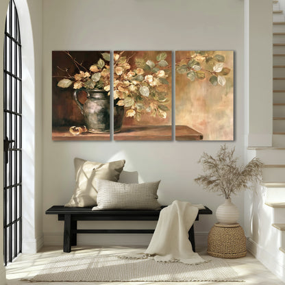 Pale golden blossoms and leaves in a dark green vase on a wooden ledge 3 piece canvas wall art displayed in a entryway