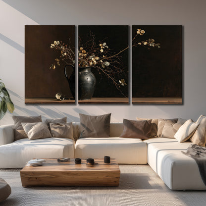 Fine flowering branches in a small dark vase on a wooden table against a deep brown background 3 piece canvas wall art displayed in a living room