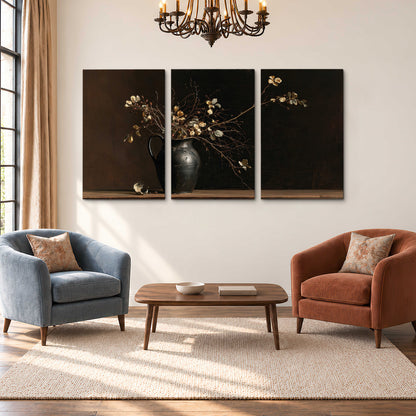 Fine flowering branches in a small dark vase on a wooden table against a deep brown background 3 piece canvas wall art styled in an interior