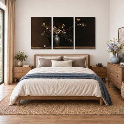 Fine flowering branches in a small dark vase on a wooden table against a deep brown background 3 piece canvas wall art styled in an interior