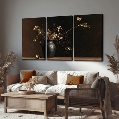 Fine flowering branches in a small dark vase on a wooden table against a deep brown background 3 piece canvas wall art displayed in a rustic living room