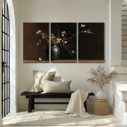 Fine flowering branches in a small dark vase on a wooden table against a deep brown background 3 piece canvas wall art displayed in a entryway