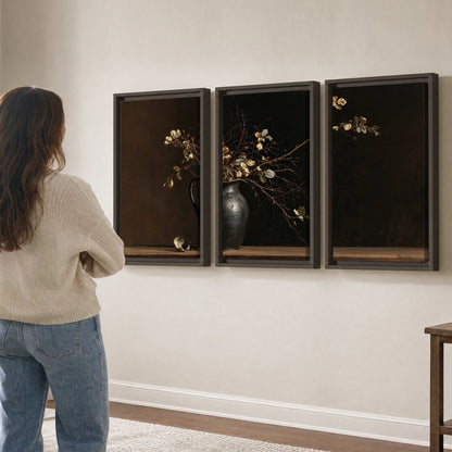 Fine flowering branches in a small dark vase on a wooden table against a deep brown background 3 piece framed canvas wall art three panel arrangement on a wall