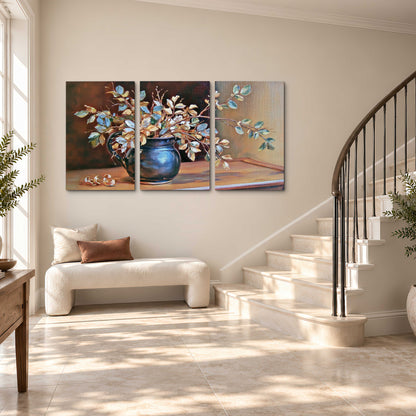 White and peach flowering branches arranged in a blue vase against a warm ochre background 3 piece canvas wall art styled in an interior