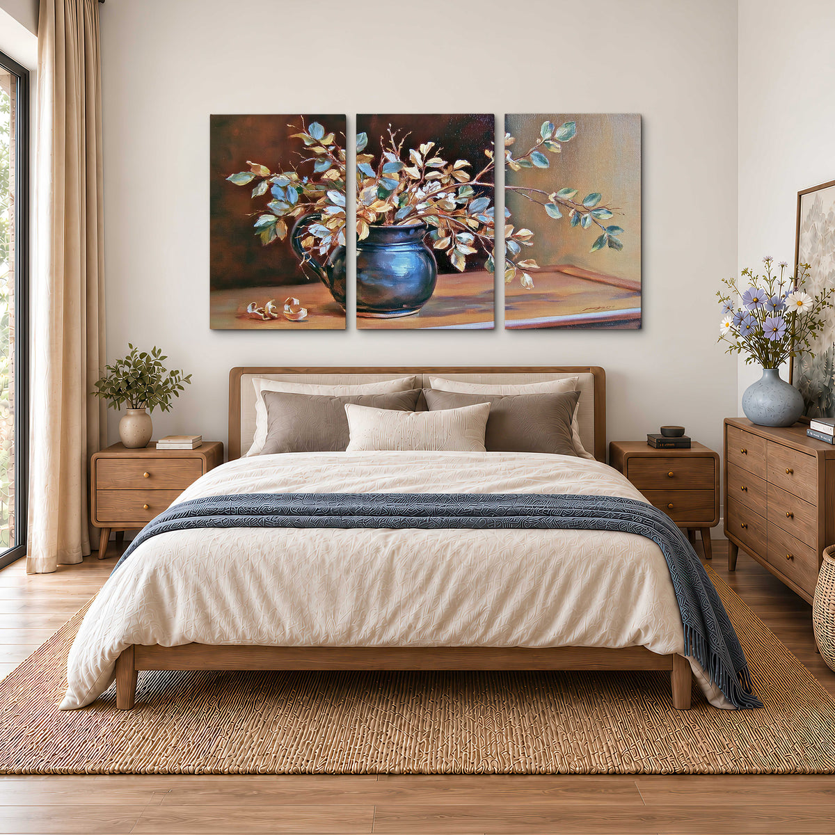 White and peach flowering branches arranged in a blue vase against a warm ochre background 3 piece canvas wall art styled in an interior