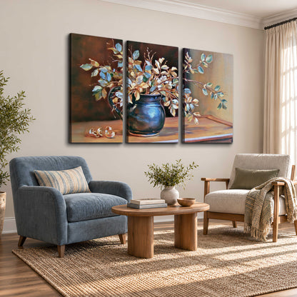 White and peach flowering branches arranged in a blue vase against a warm ochre background 3 piece canvas wall art styled in an interior