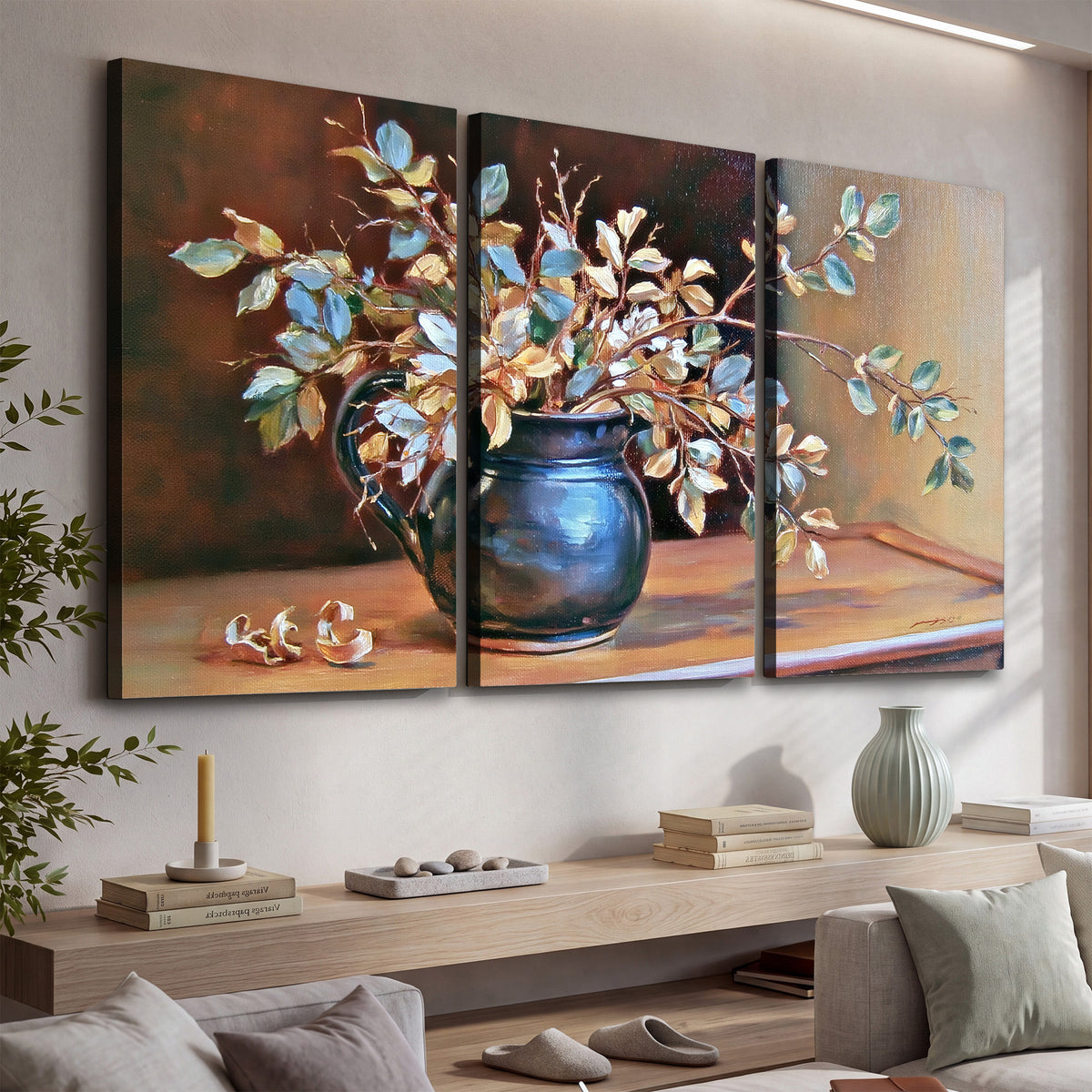 White and peach flowering branches arranged in a blue vase against a warm ochre background 3 piece canvas wall art displayed in a console