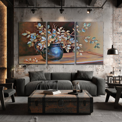 White and peach flowering branches arranged in a blue vase against a warm ochre background 3 piece canvas wall art displayed in a industrial room